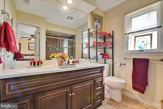 bathroom with tile patterned floors, vanity, a shower with door, ceiling fan, and toilet