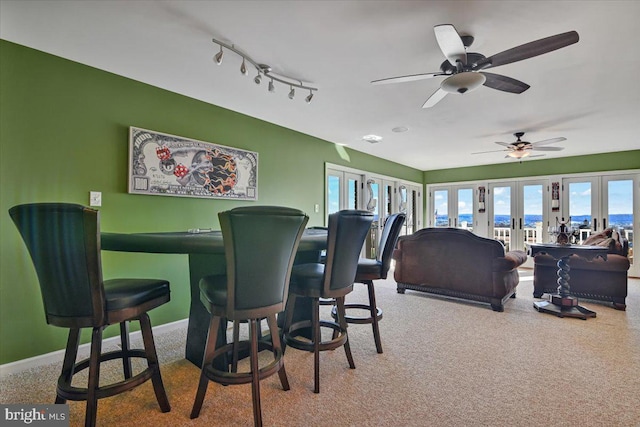 carpeted dining area featuring french doors and ceiling fan