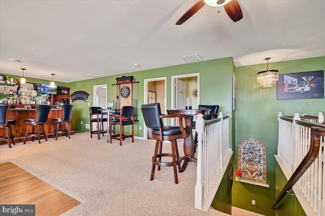 interior space with decorative light fixtures, carpet floors, and ceiling fan with notable chandelier