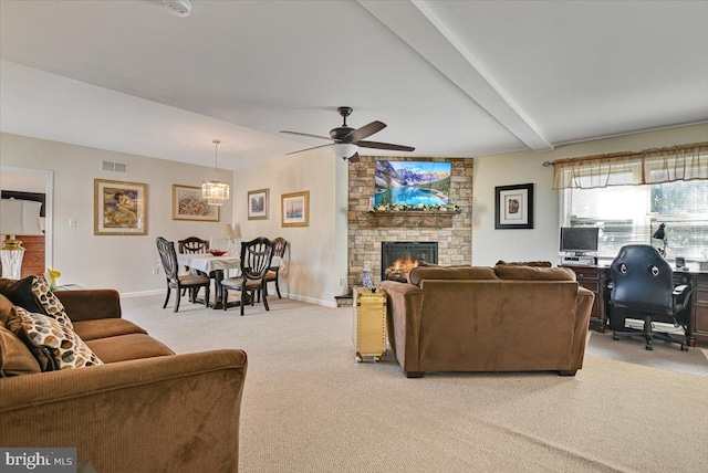 carpeted living room featuring beamed ceiling, ceiling fan, and a stone fireplace