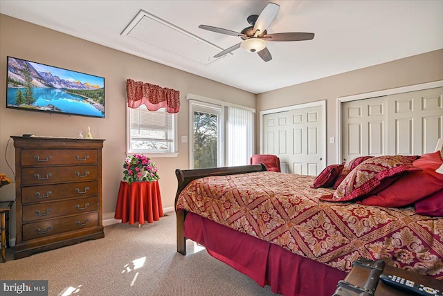 carpeted bedroom featuring two closets and ceiling fan