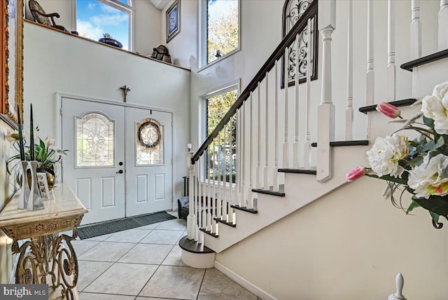 tiled foyer with a wealth of natural light and a towering ceiling