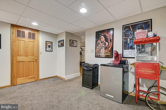 interior space with a paneled ceiling and carpet