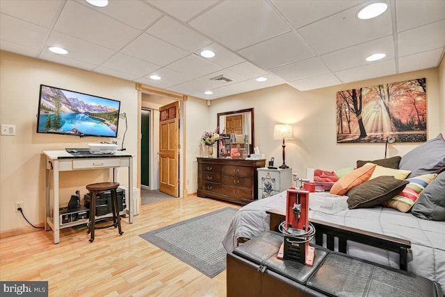 living room with a paneled ceiling and light hardwood / wood-style floors