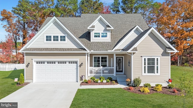 craftsman-style house featuring covered porch, a front yard, and a garage