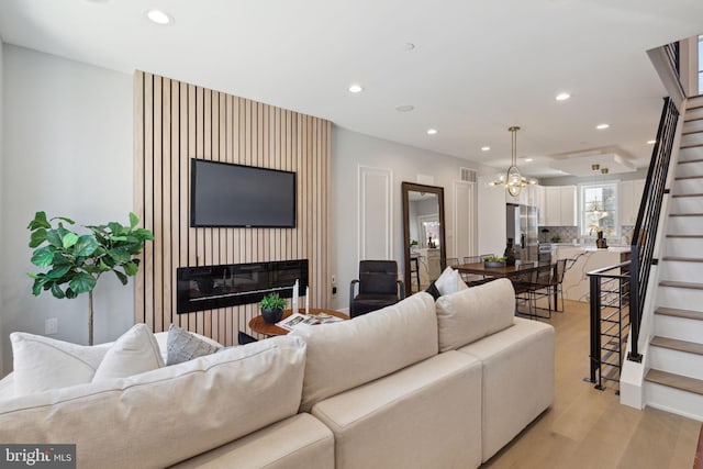 living room with an inviting chandelier and light wood-type flooring