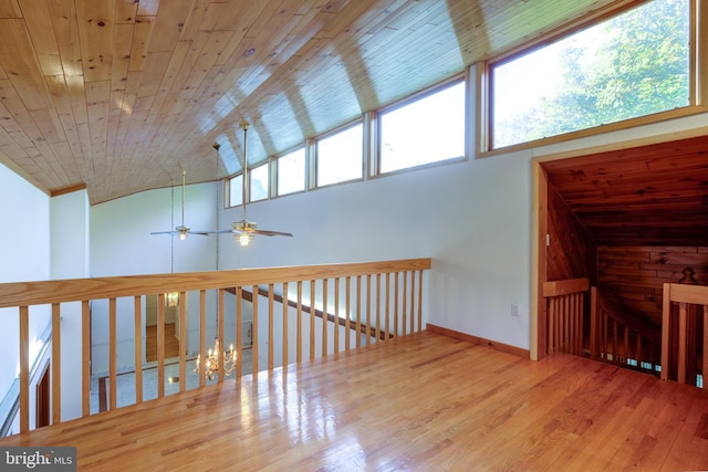 bonus room featuring hardwood / wood-style floors, wooden ceiling, ceiling fan with notable chandelier, and plenty of natural light