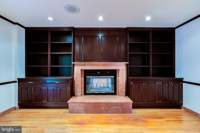 unfurnished living room with crown molding, light hardwood / wood-style flooring, and a fireplace