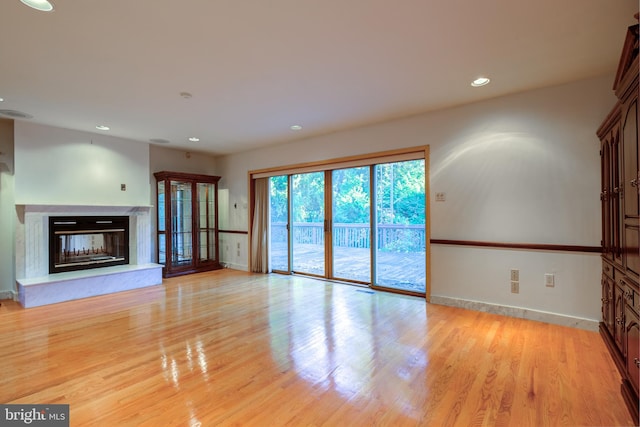 unfurnished living room with light hardwood / wood-style flooring and a high end fireplace