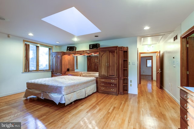 bedroom with light hardwood / wood-style floors and a skylight