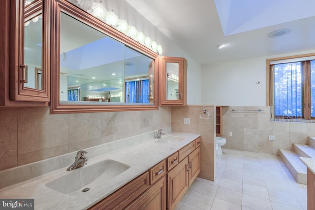 bathroom featuring tile walls, vanity, toilet, and tile patterned flooring