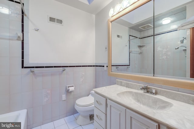 bathroom featuring vanity, toilet, tile walls, and tile patterned flooring