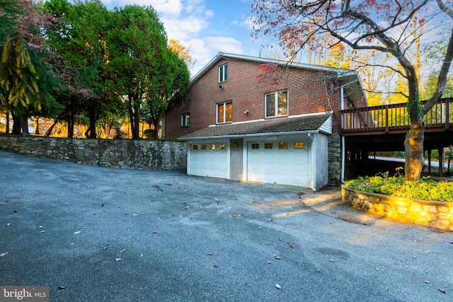 view of side of home featuring a wooden deck and a garage