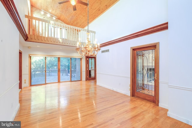 spare room with light hardwood / wood-style floors, ceiling fan with notable chandelier, high vaulted ceiling, and wooden ceiling