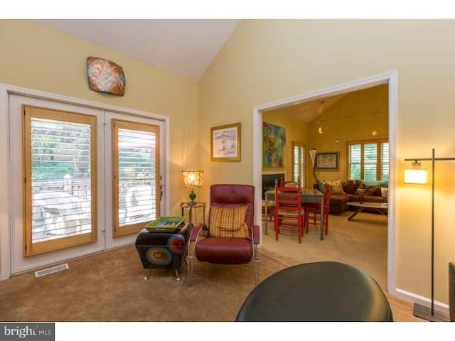 sitting room featuring vaulted ceiling and light colored carpet