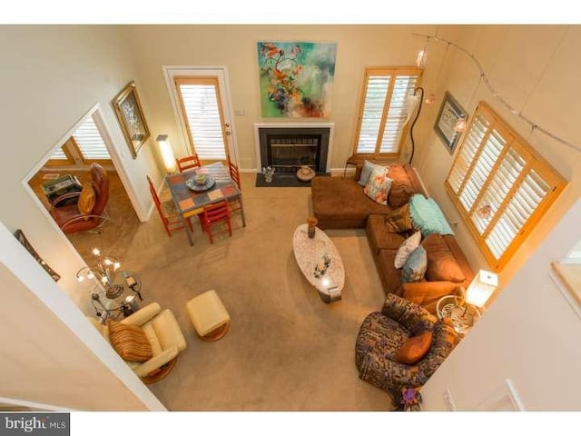 carpeted living room with a towering ceiling