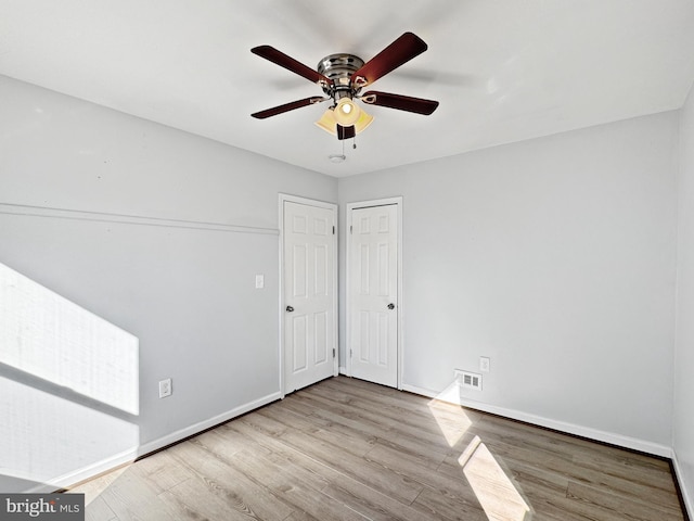 spare room with ceiling fan and light wood-type flooring