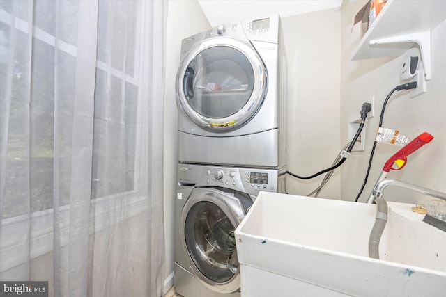 clothes washing area with sink and stacked washer and clothes dryer