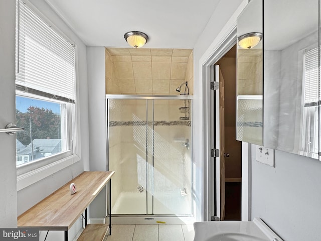 bathroom with a wealth of natural light, tile patterned flooring, and an enclosed shower