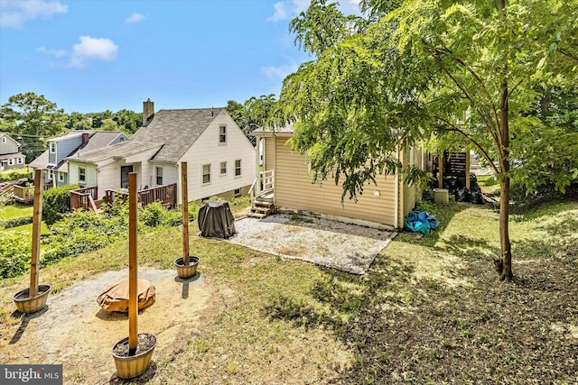 back of house with a wooden deck and a yard