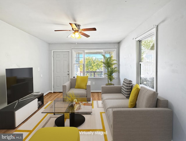 living room featuring light hardwood / wood-style floors, ceiling fan, and a wealth of natural light