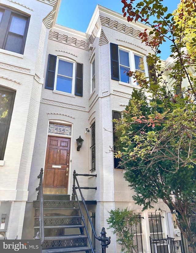 view of front of house with entry steps and brick siding