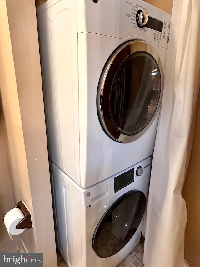 laundry room with stacked washer / dryer and laundry area