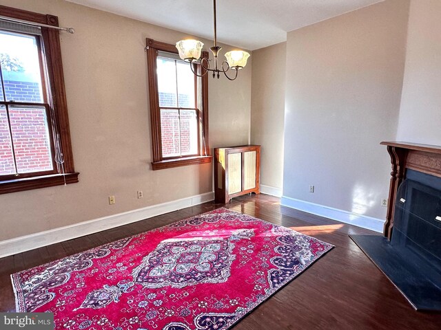 dining area with wood finished floors, a notable chandelier, and baseboards