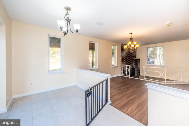 interior space featuring an inviting chandelier, hardwood / wood-style flooring, and a fireplace