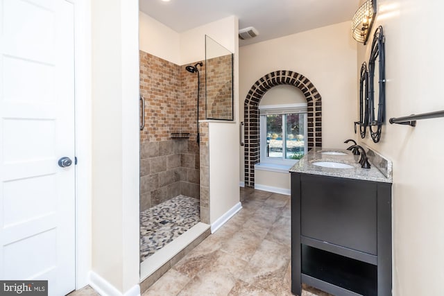 bathroom with vanity and tiled shower