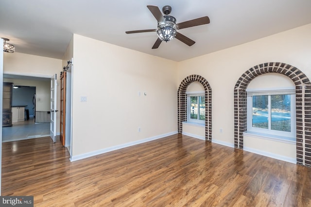 empty room with ceiling fan and hardwood / wood-style floors