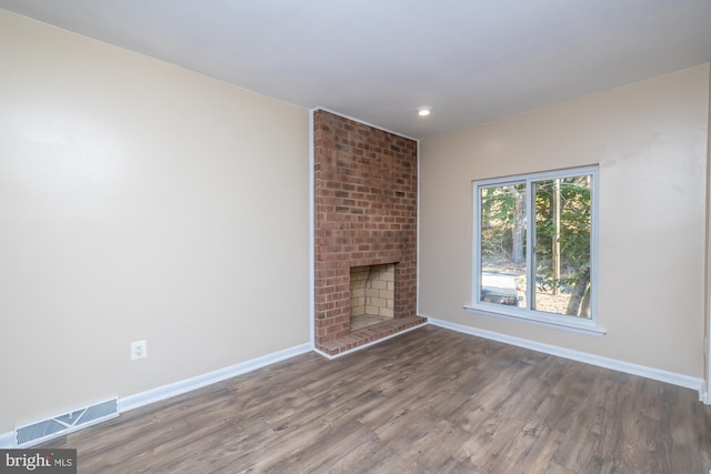 unfurnished living room with wood-type flooring and a fireplace