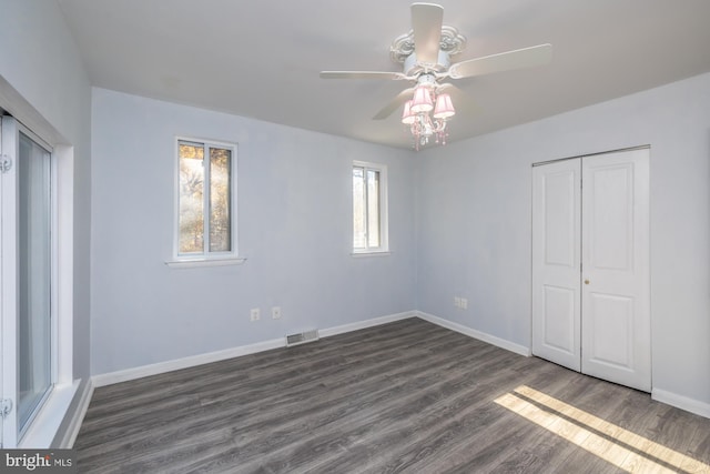 unfurnished bedroom featuring ceiling fan, a closet, and dark hardwood / wood-style flooring