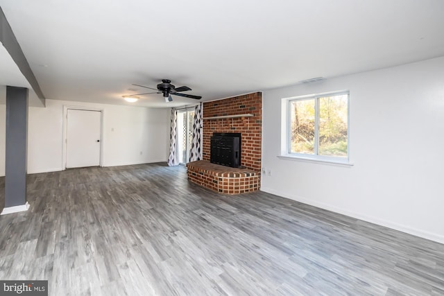 unfurnished living room with hardwood / wood-style floors, a fireplace, and ceiling fan