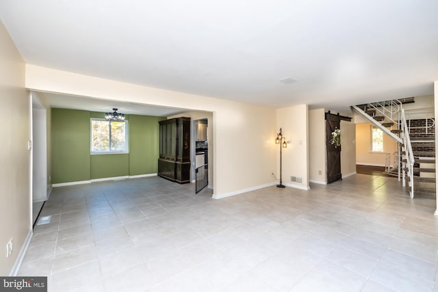 tiled spare room with a barn door