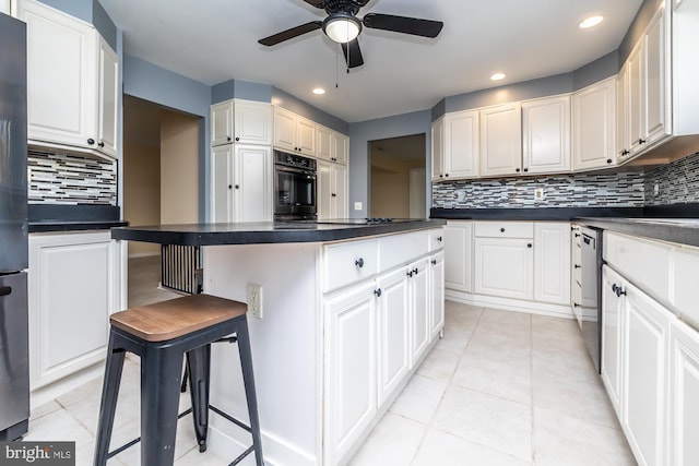 kitchen with white cabinetry, tasteful backsplash, black appliances, and a kitchen breakfast bar