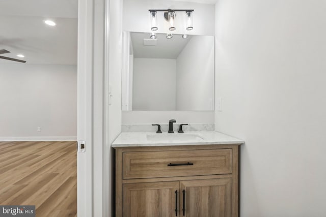 bathroom with vanity, hardwood / wood-style flooring, and ceiling fan