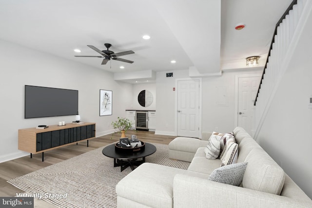 living room featuring wood-type flooring, ceiling fan, and beverage cooler