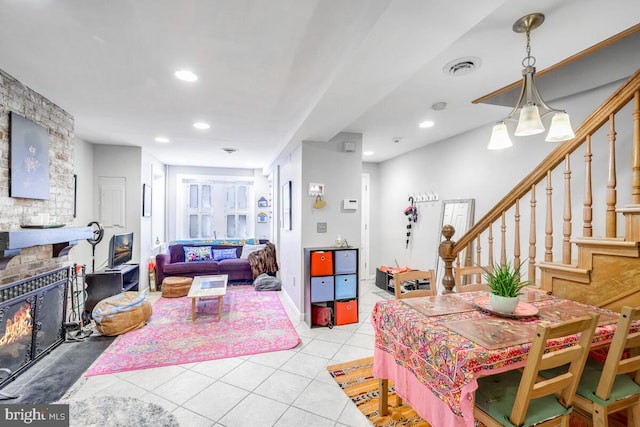 dining room featuring light tile patterned floors and a large fireplace