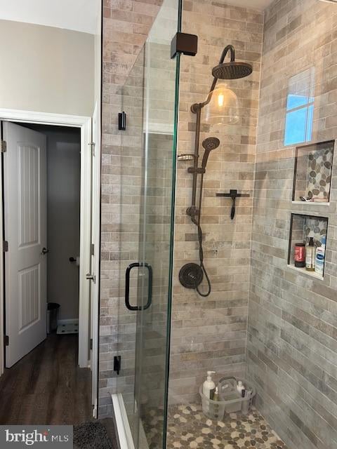 bathroom featuring hardwood / wood-style floors and a shower with shower door