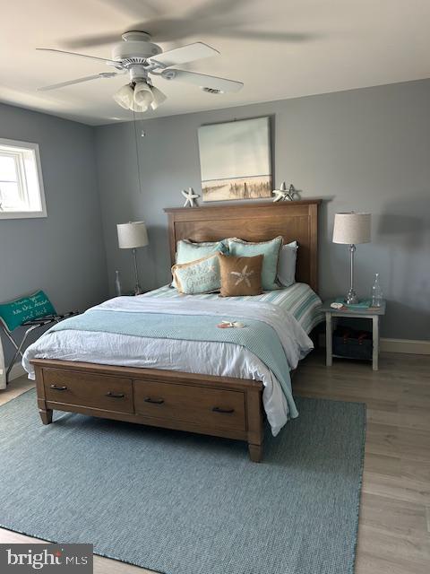 bedroom with light hardwood / wood-style flooring and ceiling fan