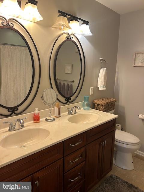 bathroom with vanity, toilet, and tile patterned floors