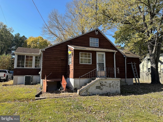 view of front of house with central AC and a front lawn