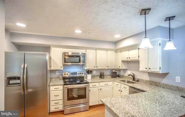 kitchen featuring sink, hanging light fixtures, stainless steel appliances, white cabinets, and light hardwood / wood-style flooring