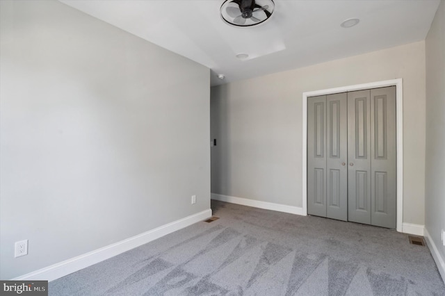 unfurnished bedroom with a closet and light carpet