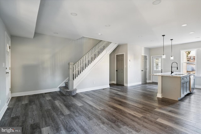 unfurnished living room featuring sink and dark wood-type flooring