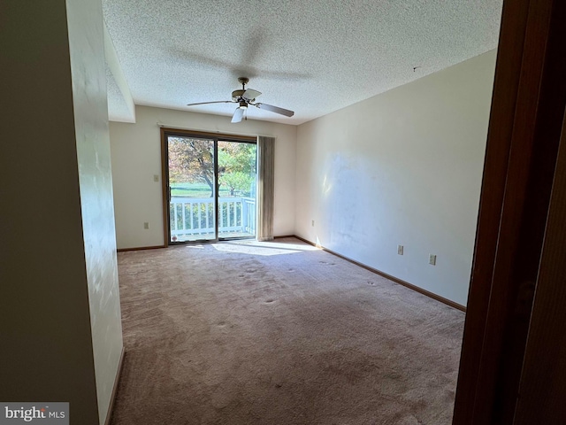 unfurnished room featuring ceiling fan, light carpet, and a textured ceiling