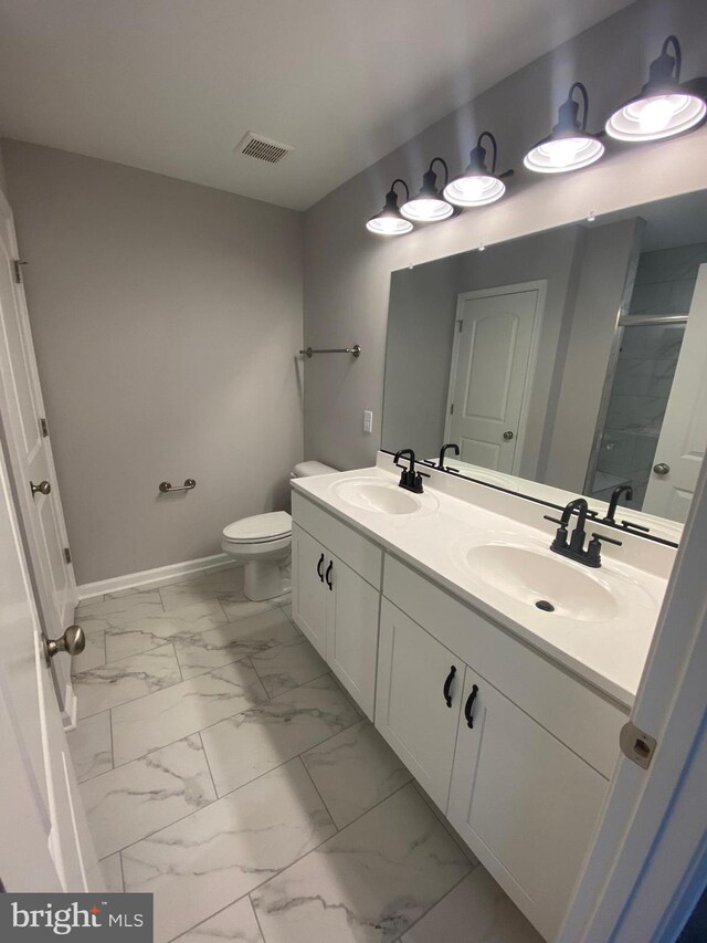 bathroom featuring vanity, toilet, and a shower with door