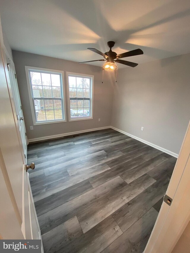 unfurnished room with ceiling fan and dark hardwood / wood-style flooring