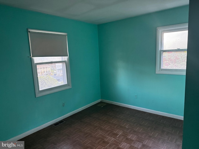 empty room featuring dark parquet flooring